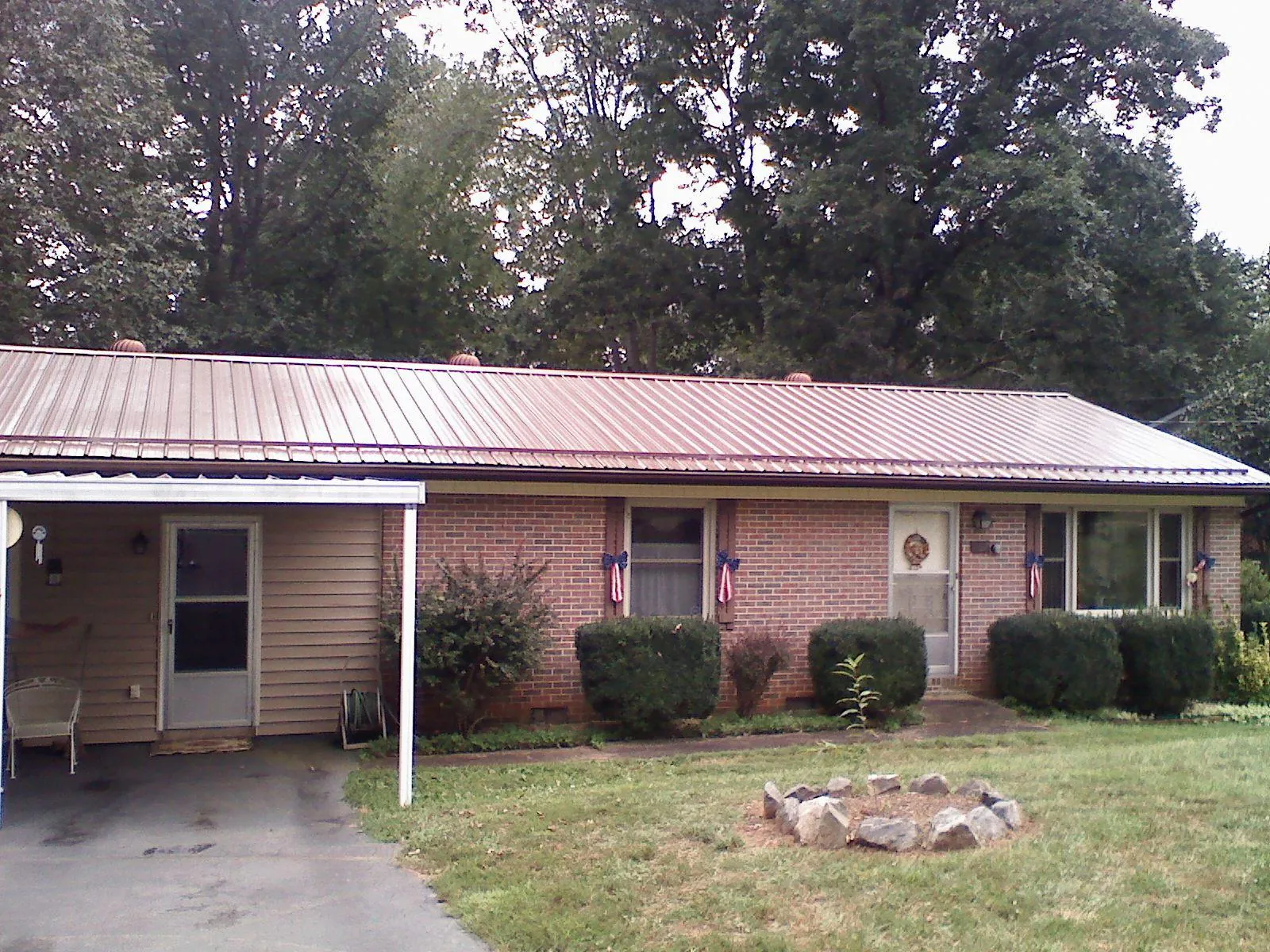 Bronze metal roof and carport on a brick ranch home — Roof Repair work by our crew in Cressey